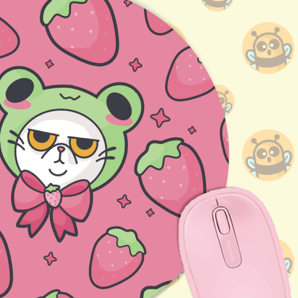 This image shows an hand-drawn adorable mousepad, Grompy Kitty With Frog Hat Mousepad, which is available to purchase from HunnieByte.com