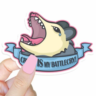 This image shows our adorable sticker finishes, Crying Is My Battlecry Possum Sticker, which is available to purchase from HunnieByte.com