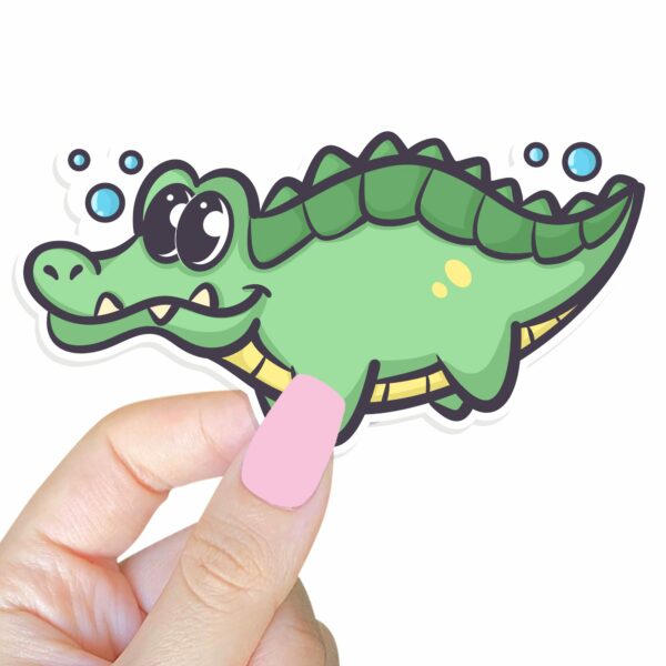 This image shows an hand-drawn adorable sticker, Lenny The Gator Swimming Sticker, which is available to purchase from HunnieByte.com