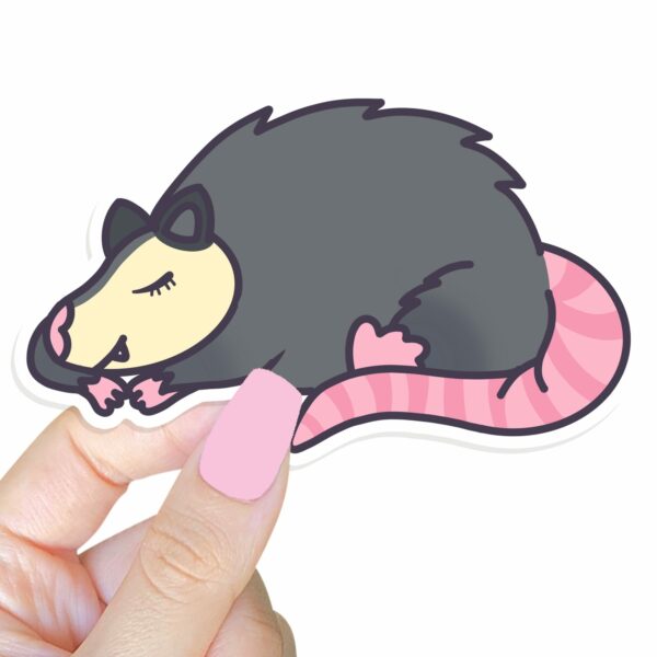 This image shows an hand-drawn adorable sticker, Sleeping Possum Sticker, which is available to purchase from HunnieByte.com