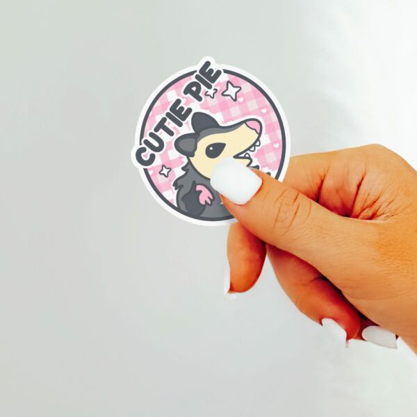 This image shows an hand-drawn adorable sticker, Cutie Pie Possum Sticker, which is available to purchase from HunnieByte.com