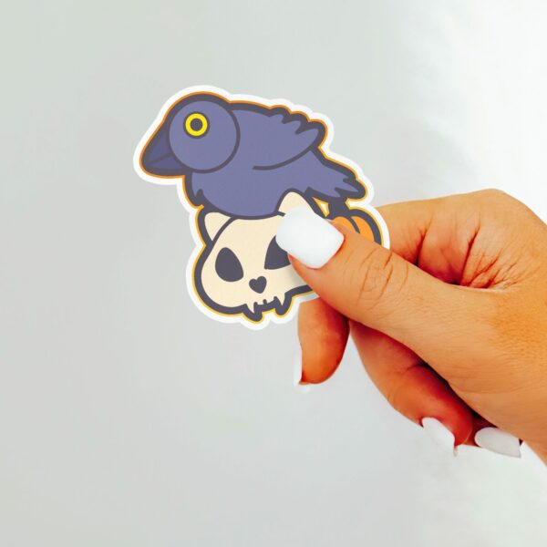 This image shows an hand-drawn adorable sticker, Crow and Skull Sticker, which is available to purchase from HunnieByte.com