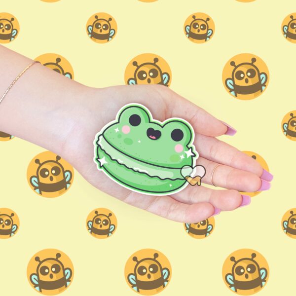 This image shows an hand-drawn adorable sticker, Frog Macaroon Sticker, which is available to purchase from HunnieByte.com