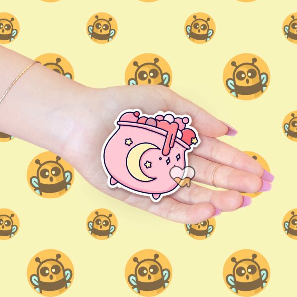 This image shows an hand-drawn adorable sticker, Pretty Pink Cauldron Sticker, which is available to purchase from HunnieByte.com