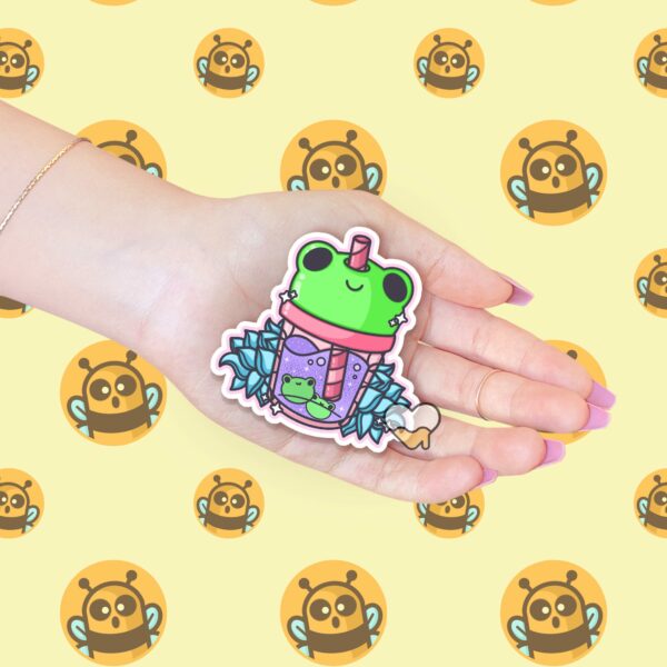 This image shows an hand-drawn adorable sticker, Frog Lotus Juice Sticker, which is available to purchase from HunnieByte.com