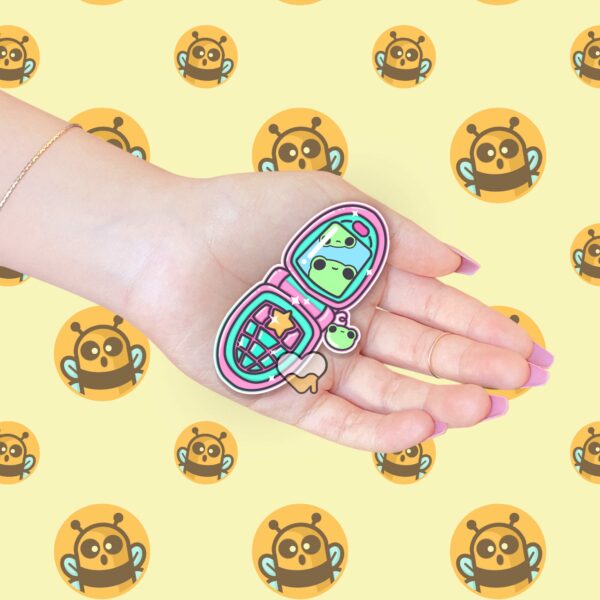 This image shows an hand-drawn adorable sticker, Froggy Flip Phone Sticker, which is available to purchase from HunnieByte.com