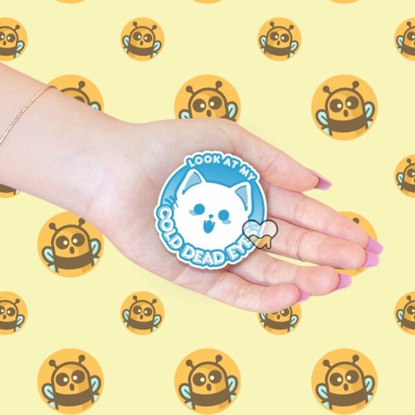 This image shows our adorable sticker finishes, Look At My Cold Dead Eyes Cat Sticker, which is available to purchase from HunnieByte.com