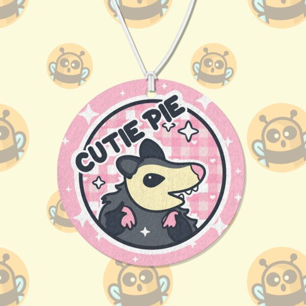 This image shows an adorable hand-drawn air freshener, Cutie Pie Possum Air Freshener, which is available to purchase from HunnieByte.com